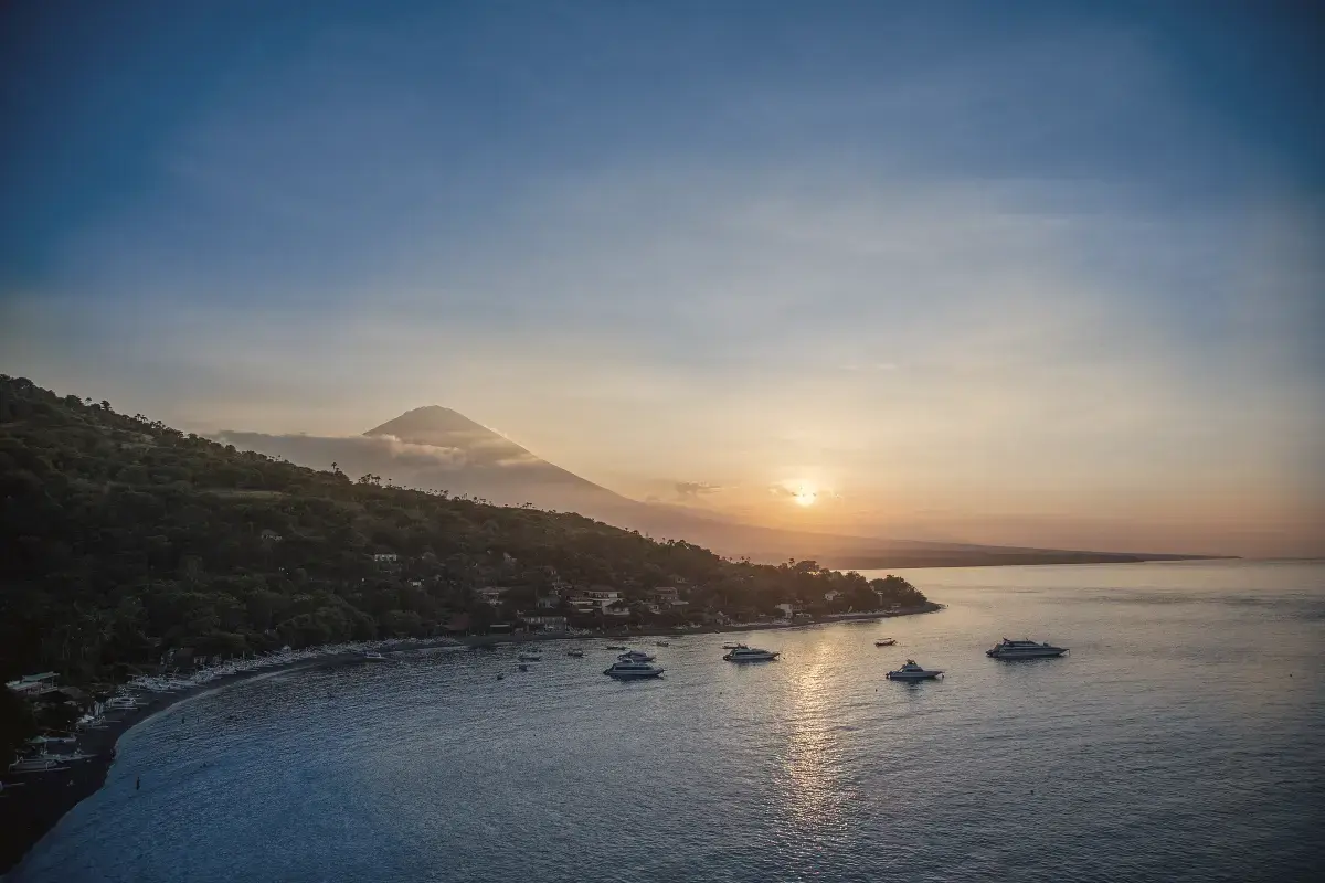 Mount Agung at golden hour above Amed bay and its moored boats, east Bali
