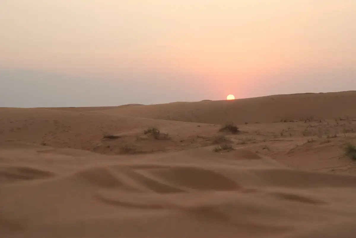 Sun setting over soft sand dunes in the desert near Dubai